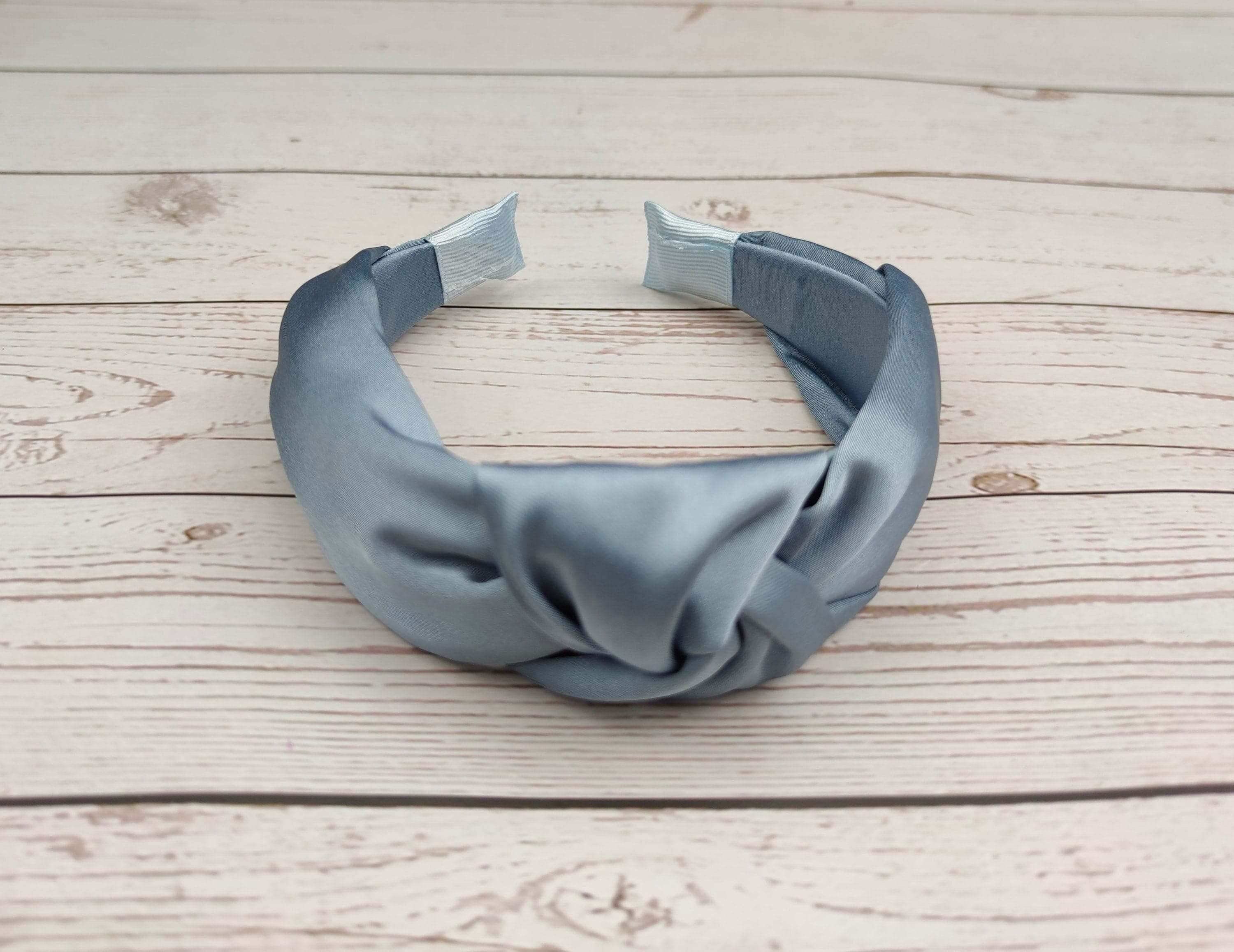 Stay comfortable and stylish with this light blue headband, designed with a knot twist and made from satin material.