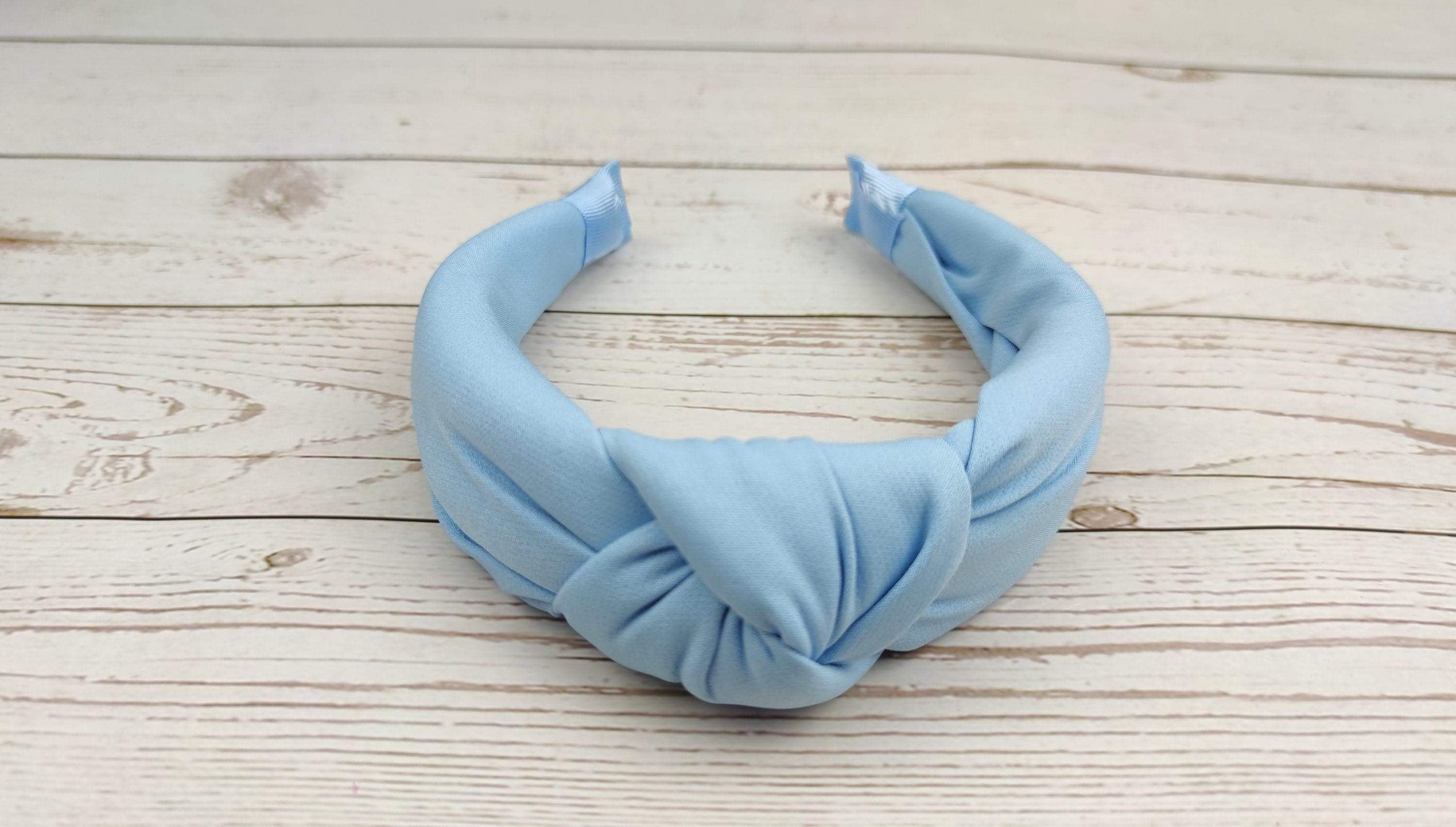 Add a pop of color to your hairstyle with this light blue viscose crepe padded headband.