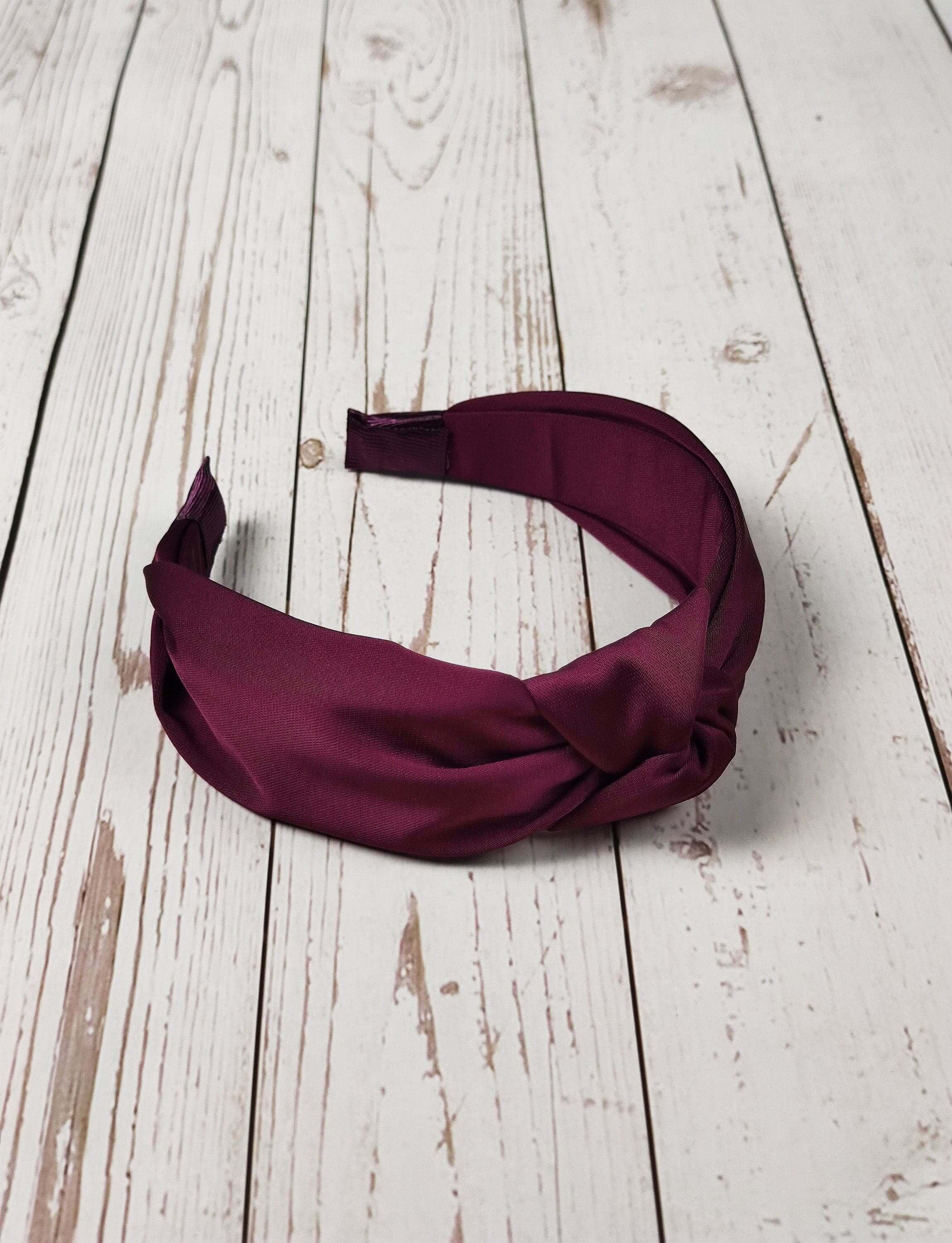 The perfect accessory for any occasion: a fashionable maroon satin knotted headband.