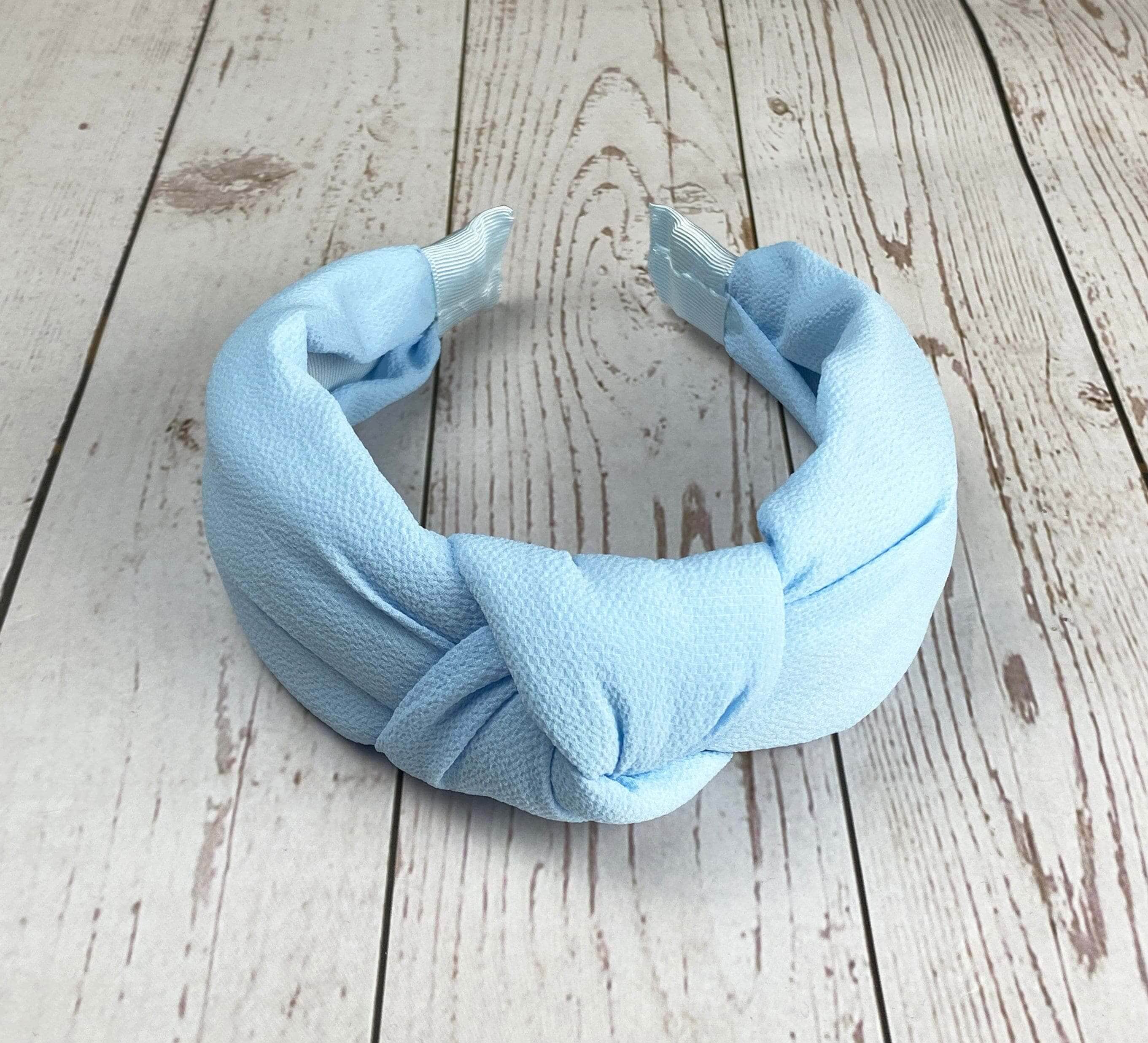 Stay comfortable and stylish with this baby blue twist knot headband, made from soft viscose crepe material and padded for extra comfort.