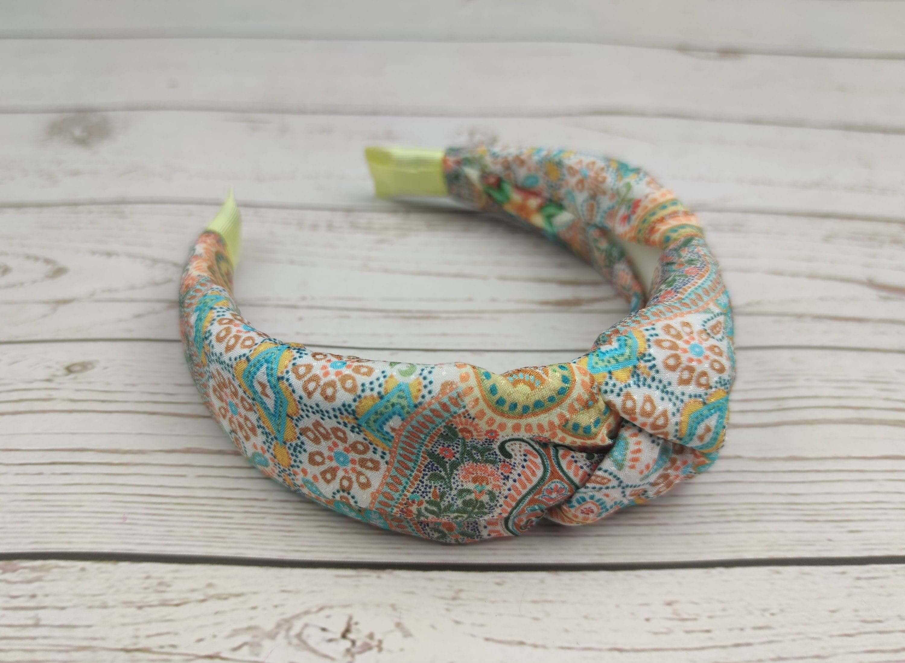 A vibrant headband featuring a colorful knot design in pastel shades.