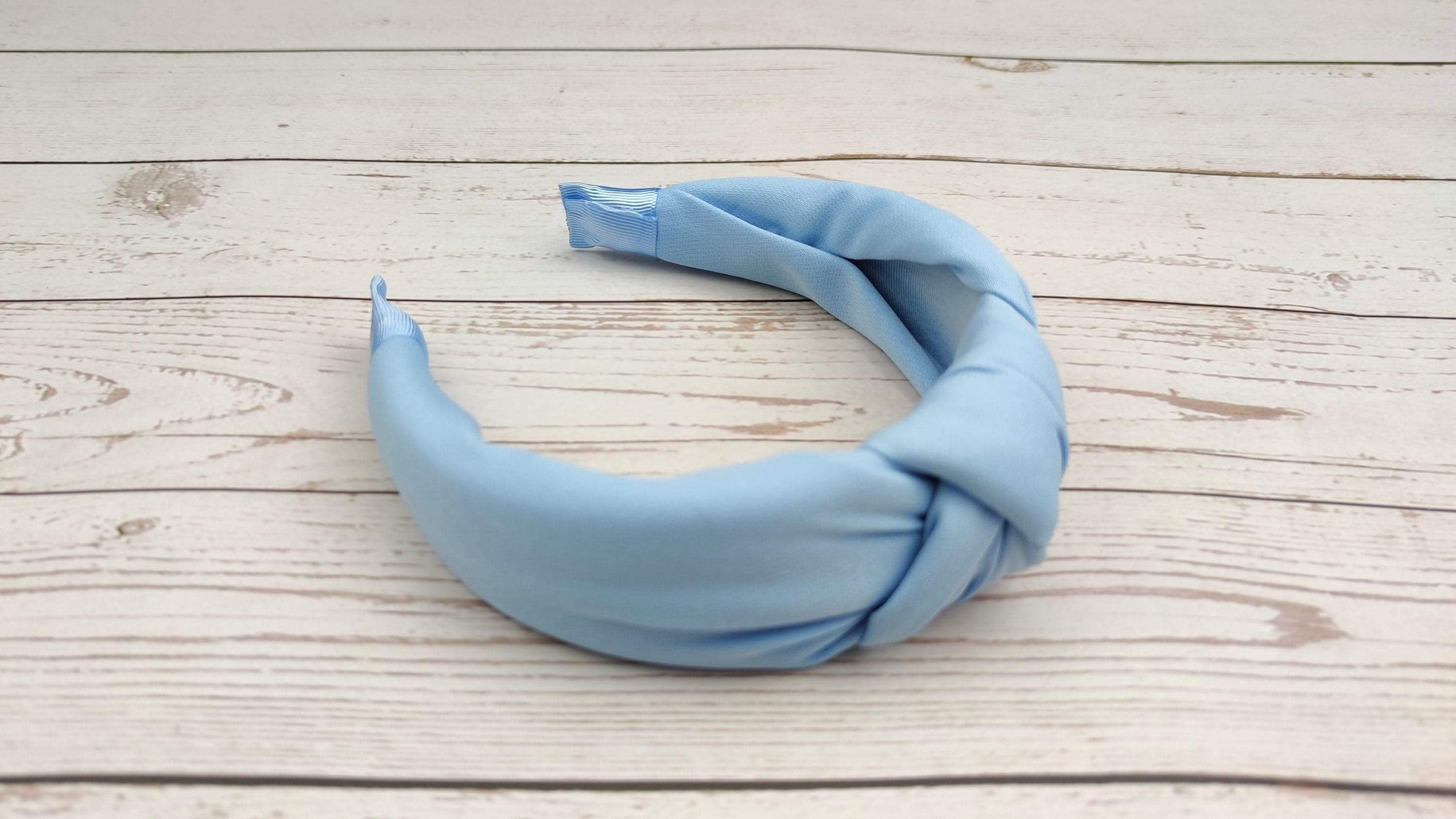 The perfect accessory for any hairstyle: a chic twist knot headband in bright light blue.
