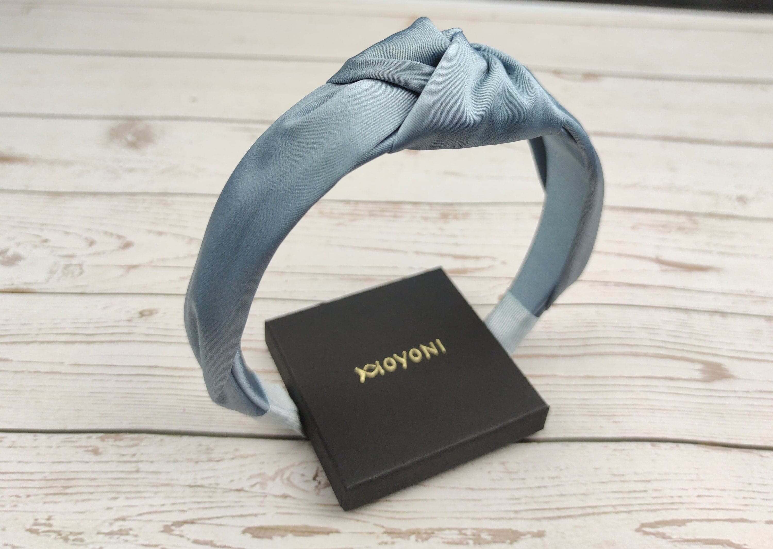 Make a fashion statement with this light blue headband, designed with a knot twist and made from soft and luxurious satin material.
