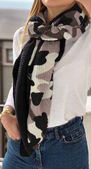 Dark-colored scarf featuring a bold camouflage pattern, made from 100% cotton.