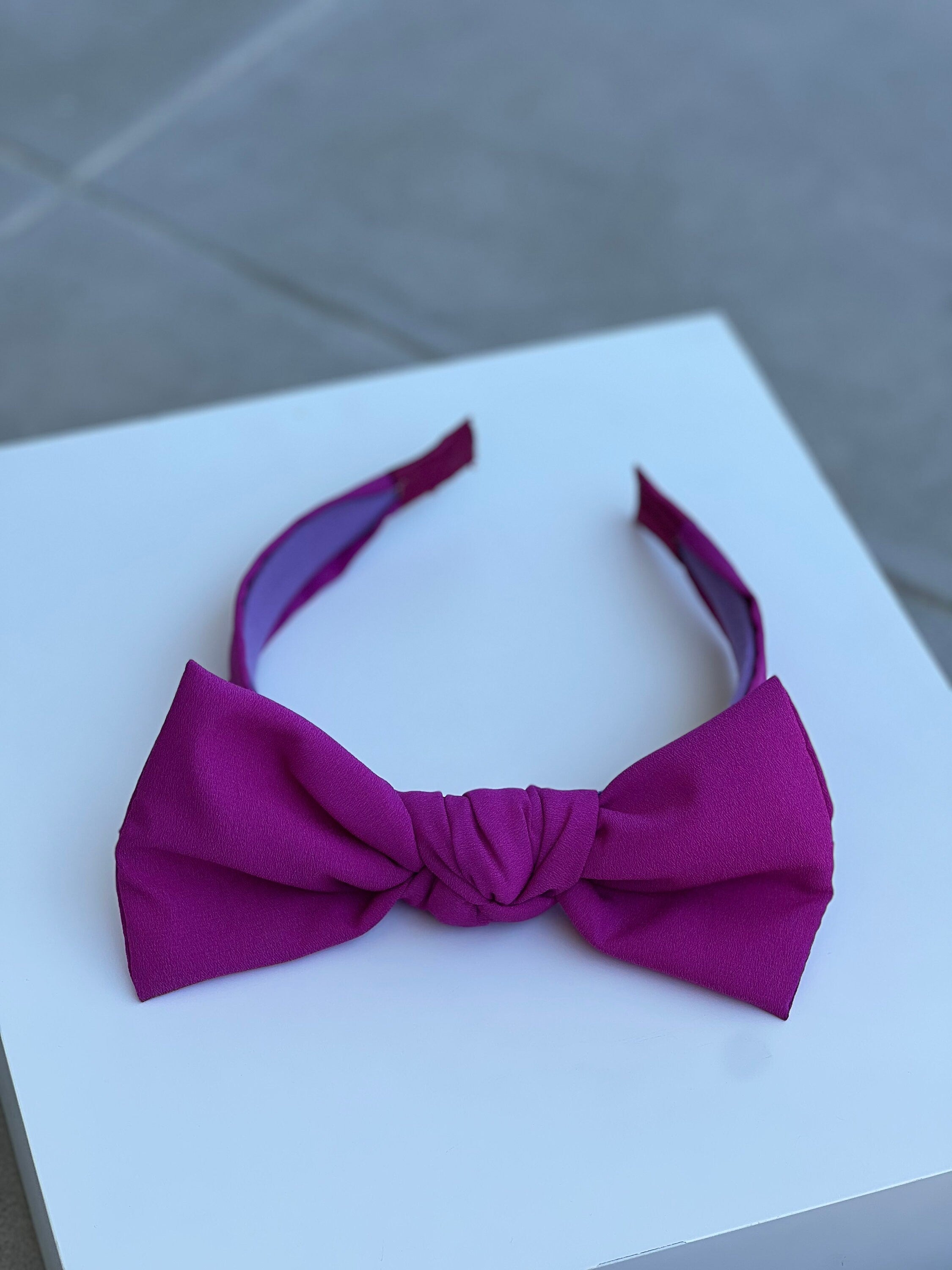 Stay stylish and comfortable with this classic fuschia tie headband