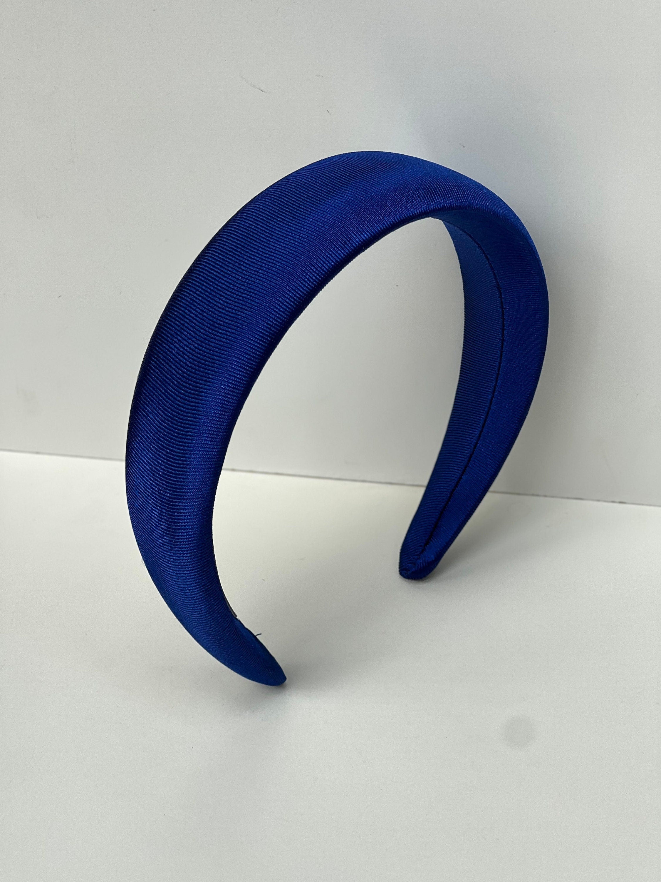 Make a statement with this bright blue satin headband, perfect for adding a pop of color to any hairstyle.